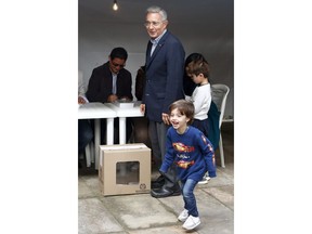 Former President Alvaro Uribe looks at a grand child after voting during the presidential runoff election in Bogota, Colombia, Sunday, June 17, 2018. Uribe's protégée Ivan Duque defeated Gustavo Petro, a former leftist rebel and ex-Bogota mayor.
