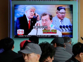 FILE - In this March 7, 2018, file photo, people watch a TV screen showing images of North Korean leader Kim Jong Un, right, South Korean President Moon Jae-in, center, and U.S. President Donald Trump during a news program at the Seoul Railway Station in Seoul, South Korea. The on-again, off-again meeting between President Donald Trump and North Korean leader Kim Jong Un has been an emotional roller coaster for South Koreans. With the summit now set for Tuesday, they await the historic event with both hopes and doubts. The signs read: "Thawing Korean Peninsula."