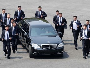 FILE - In this April 27, 2018, file photo, North Korean security persons run by a car carrying North Korean leader Kim Jong Un return to the North side for a lunch break after a morning meeting with South Korean President Moon Jae-in at the border village of Panmunjom in Demilitarized Zone. Kim is on a rare trip abroad as he leaves the all-encompassing bubble of his locked-down stronghold of Pyongyang and steps off a jet onto Singaporean soil for his planned sit-down witU.S. President Donald Trump on Tuesday, June 12, 2018. (Korea Summit Press Pool via AP, File)