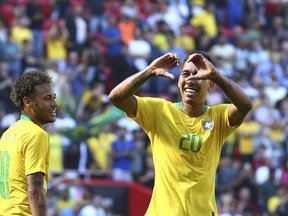 Brazil's Roberto Firmino, right, celebrates with team mate Neymar after scoring his side's second goal during the friendly soccer match between Brazil and Croatia at Anfield Stadium in Liverpool, England, Sunday, June 3, 2018.