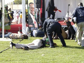 EDS NOTE GRAPHIC CONTENT Injured people lay on the ground following an explosion at a Zanu pf rally in Bulawayo, Saturday, June, 23, 2018.  An explosion rocked a stadium where Zimbabwe's president was addressing a campaign rally on Saturday, with state media calling it an assassination attempt but saying he was not hurt and was evacuated from the scene. Witnesses said several people were injured, including a vice president. (AP Photo)