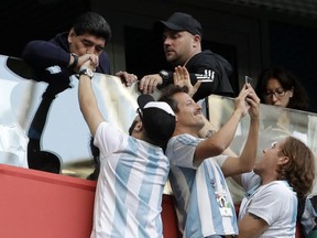 Argentina former soccer star Diego Maradona kisses the hand of a soccer fan ahead of the group D match between Argentina and Nigeria, at the 2018 soccer World Cup in the St. Petersburg Stadium in St. Petersburg, Russia, Tuesday, June 26, 2018.