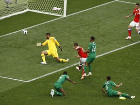 Russia's Denis Cheryshev, center, scores his side's second goal during the group A match between Russia and Saudi Arabia which opens the 2018 soccer World Cup at the Luzhniki stadium in Moscow, Russia, Thursday, June 14, 2018.