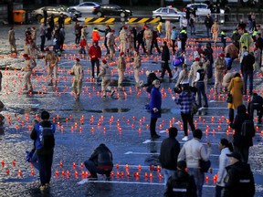 People light candles during a WWII commemoration, in Yekaterinburg, Russia, during the 2018 soccer World Cup, Friday, June 22, 2018. Members of the Young army, a youth organization funded by the Russian defense ministry, along with cadets of the emergency situations ministry of Russia, and city residents commemorated 77 years since troops of Nazi Germany invaded the Soviet union during WWII.