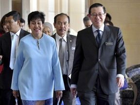 Malaysian Finance Minister Lim Guan Eng, right, walks with newly appointed National Bank Gov. Nor Shamsiah Mohamad Yunus, front left, to attend a press conference in Putrajaya, Malaysia, Friday, June 22, 2018. Lim said that the king has consented to Nor Shamsiah's appointment to head Bank Negara Malaysia from July 1 for a five-year term. (AP Photo)