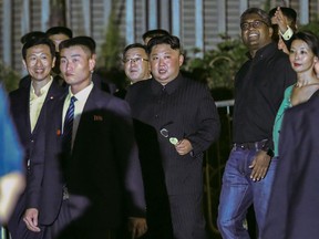 North Korea leader Kim Jong Un, center, is escorted by his security delegation as he visits Marina Bay in Singapore, Monday, June 11, 2018, ahead of Kim's summit with U.S. President Donald Trump.