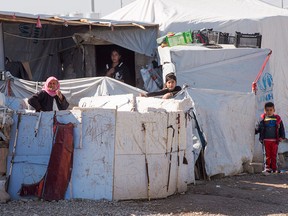 A Yazidi family looks out from their accommodations at a camp for displaced persons in Dohuk, Iraq, on Feb. 22, 2017.