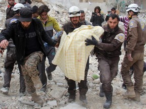 Members of the Syrian civil defence, known as the White Helmets, remove a victim from the rubble of a destroyed building following a reported air strike in the northwestern city of Idlib on March 15, 2017.