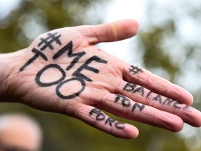 This file photo taken on October 29, 2017 shows the messages "#Me too" and "#Balancetonporc" (expose your pig) on the hand of a protester during a gathering against gender-based and sexual violence called by the Effronte-e-s Collective, on the Place de la Republique square in Paris on October 29, 2017.