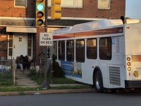 In this Thursday, July 5, 2018 photo, a Southeastern Pennsylvania Transportation Authority (SEPTA) bus rests on the front yard of a house after crashing in Philadelphia. Police Chief Inspector Scott Small said three people were on the front lawn when the bus hit, and a 53-year-old man died at the scene. The two others on the lawn have been hospitalized, as well as the 49-year-old bus driver.