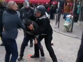 In this image taken from video, a man identified as Alexandre Benalla, right, a security chief to French President Emmanuel Macron, confronting a student during a May Day demonstration in Paris, May 1, 2018.  The video came to light Thursday July 19, 2018, showing one of Macron's security chiefs beating a student demonstrator,