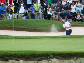 Dustin Johnson plays a shot from a bunker on the 18th hole on Saturday during the third round at the RBC Canadian Open at Glen Abbey Golf Club in Oakville, Ont.
