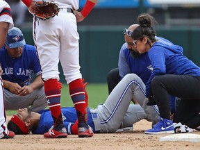 Lourdes Gurriel Jr. #13 of the Toronto Blue Jays is examined by trainers after suffering an apparent leg injury in the 9th inning against the Chicago White Sox at Guaranteed Rate Field on July 29, 2018 in Chicago, Illinois.