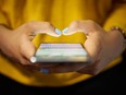 A young woman uses a cell phone to send a text message.