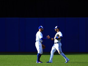 In this Sept. 24, 2017 file photo, Toronto Blue Jays right fielder Jose Bautista (right) shakes hands with centre fielder Kevin Pillar after being pulled in the ninth inning from a game against the New York Yankees.