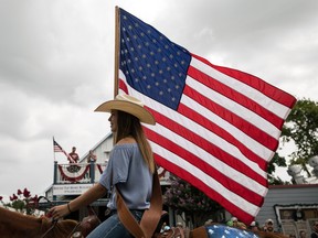 ROUND TOP, TX - JULY 04: Kaitlyn Tarnoswki, 14, carries an American flag while riding a horse during the 168th annual Round Top Fourth of July Parade on July 4, 2018 in Round Top, Texas.