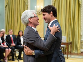 Jim Carr hugs Justin Trudeau at the Cabinet shuffle on July 18.