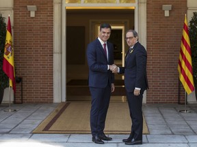 Spain's Prime Minister Pedro Sanchez, left, welcomes Catalan regional president, Quim Torra, on his arrival at the Moncloa palace in Madrid, Monday, July 9, 2018.