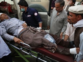 An injured man is put into an ambulance following a deadly attack outside the Rural Rehabilitation and Development Ministry in Kabul, Afghanistan, Sunday, July 15, 2018. An Afghan official said several people were killed and others wounded when a suicide bomber detonated his suicide vest in the country's capital.