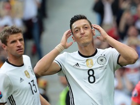 In this file photo taken on June 26, 2016, Germany's midfielder Mesut Ozil (R) reacts during the Euro 2016 round of 16 football match between Germany and Slovakia at the Pierre-Mauroy stadium in Villeneuve-d'Ascq near Lille on June 26, 2016.
