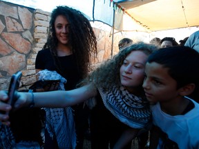 Palestinian activist and campaigner Ahed Tamimi (C) takes a selfie with friends in the West Bank village of Nabi Saleh on July 29, 2018, upon her release from prison after an eight-month sentence.