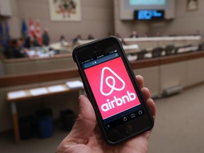 A man holds his phone with the Airbnb app open. nyone renting an Airbnb listing in the nation’s capital will have to start paying a hotel tax when the calendar turns to August.
The tax revenue will flow into municipal coffers.