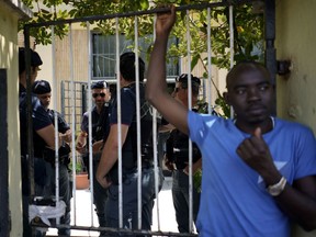 A migrants stands outside a building after being evicted by police in Rome, Thursday, July 5, 2018. Over 100 migrants, most of them refugees, were evicted from a squatted building in Rome.