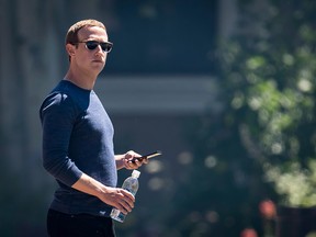 Mark Zuckerberg, chief executive officer and founder of Facebook Inc., holds his phone after the morning session at the Allen & Co. Media and Technology Conference in Sun Valley, Idaho, U.S., on Friday, July 13, 2018.