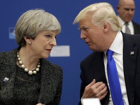 FILE- In this Thursday, May 25, 2017 file photo, U.S. President Donald Trump, right, speaks to British Prime Minister Theresa May during in a working dinner meeting at the NATO headquarters during a NATO summit of heads of state and government in Brussels. U.S. President Donald Trump's visit to Britain next week will take him to a palace, a country mansion and a castle _ and keep him away from noisy protests in London. Prime Minister Theresa May's office says Trump arrives Thursday, July 12, 2018 and will attend a dinner with business leaders at Blenheim Palace, Winston Churchill's birthplace.