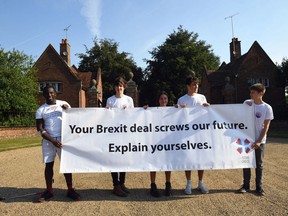 Anti-Brexit activists from Our Future Our Choice stand outside Chequers, the Prime Minister's official country residence as she gathers her fractious Cabinet to hammer out a plan for future trade with the European Union near Ellesborough in Buckinghamshire, England, Friday, July 6, 2018. The 30-strong Cabinet is being sequestered inside the prime minister's Chequers country retreat _ without their phones _ on Friday to discuss a compromise plan that May hopes will unite the government, and be accepted by the bloc.