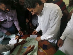 Pakistani politician Imran Khan, center, chief of Pakistan Tehreek-e-Insaf party, casts his vote at a polling station for the parliamentary elections in Islamabad, Pakistan, Wednesday, July 25, 2018. After an acrimonious campaign, polls opened in Pakistan on Wednesday to elect the country's third straight civilian government, a first for this majority Muslim nation that has been directly or indirectly ruled by its military for most of its 71-year history.