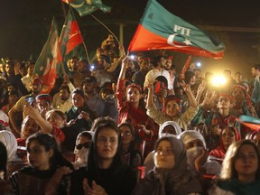 Supporters of Tehreek-e-Insaf party greet to their leader Imran Khan during an election campaign rally in Islamabad, Pakistan, Saturday, July 21, 2018. Pakistan will hold general election on July 25.