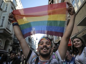 An activist brandishes a rainbow flag as Turkey's lesbian, gay, bisexual, trans and intersex activists march despite a ban, in Istanbul, Sunday, July 1, 2018.  The Istanbul LGBTI+ activists gathered in the city's Taksim neighbourhood after they announced Istanbul's local government had banned the Pride march for the fourth year in a row.