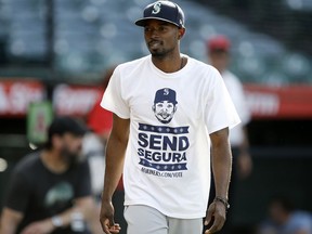 Seattle Mariners' Dee Gordon wears a "Send Segura" t-shirt, as part of a team campaign to have fans vote for Jean Segura to the All-Star game, during warmups before a baseball game against the Los Angeles Angels in Anaheim, Calif., Tuesday, July 10, 2018.