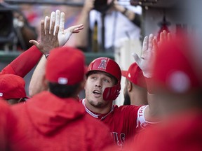 Mike Trout is congratulated in the dugout after a solo home run during the first inning of the team's baseball game against the Seattle Mariners in Anaheim, Calif., Saturday, July 28, 2018.