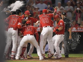 Los Angeles Angels' Kole Calhoun, second from right, is congratulated by teammates after hitting a walk-off home run on the first pitch in the bottom of the 10th inning of a baseball game against the Seattle Mariners on Friday, July 27, 2018, in Anaheim, Calif. The Angels won 4-3.