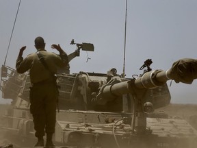 Israeli soldier guides a mobile artillery piece the near the border with Syria in the Israeli-controlled Golan Heights, Wednesday, July 25, 2018.