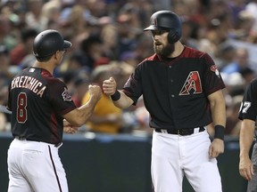 Arizona Diamondbacks' Steven Souza, right, is congratulated by third base coach Tony Perezchica (8) after Souza advanced to third on a single by Nick Ahmed during the seventh inning of a baseball game against the Colorado Rockies, Saturday, July 21, 2018, in Phoenix.