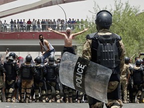 Iraqi riot police prevent protesters from storming the provincial council building during a demonstration in Basra, 340 miles (550 km) southeast of Baghdad, Iraq, Sunday, July 15, 2018. Iraqis demanding better public services and jobs took to the streets again on Sunday in the southern oil-rich province of Basra, as authorities put security forces on high alert and blocked internet on the sixth day of protests in the country's Shiite heartland. (AP Photo)