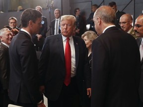 President Donald Trump, center, stops to talk with Spanish Prime Minister Pedro Sanchez, left, and Turkey's President Recep Tayyip Erdogan, right, as they attend a meeting of the North Atlantic Council during a summit of heads of state and government at NATO headquarters in Brussels on Wednesday, July 11, 2018. NATO leaders gather in Brussels for a two-day summit to discuss Russia, Iraq and their mission in Afghanistan.