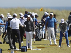 Tommy Fleetwood of England, center, practises on the driving range ahead of the British Open Golf Championship in Carnoustie, Scotland, Wednesday July 18, 2018.