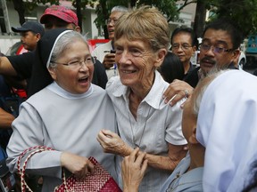 FILE - In this Friday, May 25, 2018, file photo, Australian Roman Catholic nun Sr. Patricia Fox, center, is greeted by fellow nuns as she arrives to file her at the Justice Department shortly after filing a petition seeking to review a Bureau of Immigration order revoking her missionary visa in Manila, Philippines. The Philippine immigration bureau has ordered the deportation of Sr. Patricia Fox who has angered the president by joining anti-government rallies but her lawyers call the move "persecution" and say they'll appeal.