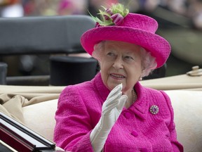 Britain's Queen Elizabeth II waves to the crowd as she arrives by open carriage into the parade ring on the third day of the Royal Ascot horse race meeting, which is traditionally known as Ladies Day, in Ascot, England.
