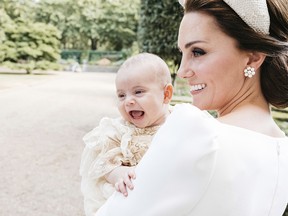 In this Monday, July 9, 2018 photo made available by Kensington Palace, Kate, the Duchess of Cambridge poses for a photo with Prince Louis in the garden of Clarence House, following Prince Louis's baptism at the Chapel Royal, St. James's Palace, in London.