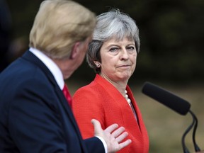 Britain's Prime Minister Theresa May and U.S. President Donald Trump answer questions during a joint press conference following their meeting at Chequers, in Buckinghamshire, England, Friday, July 13, 2018.