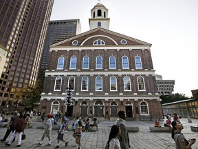FILE - In this Aug. 21, 2017, file photo, pedestrians walk past Faneuil Hall in Boston. In an open letter to Boston Mayor Marty Walsh, dated July 30, 2018, some black Bostonians are threatening a boycott because the building's 18th-century namesake was a slave owner.