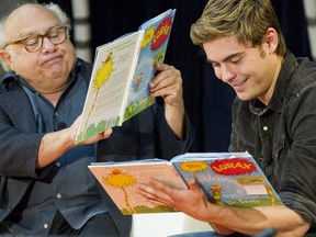 FILE - In this March. 2, 2012, file photo, stars Danny DeVito, left, and Zac Efron read "The Lorax" by Dr. Seuss to school children during the annual Read Across America Day at The New York Public Library in New York. Researchers at Dartmouth College, the alma mater of author and illustrator Theodore Geisel, better known as Dr. Seuss, said on Monday, July 23, 2018, that the furry orange protagonist of "The Lorax" and the Truffula trees may have been based on the patas monkey species and the whistling thorn acacia tree, both found in Kenya.