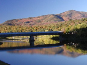 FILE - In this Monday, Oct. 14, 2002 file photo, a covered bridge, center, that runs between Cornish, N.H., and Windsor, Vt., is reflected in the Connecticut River along with Mount Ascutney, top right, in a view from the Cornish side of the river. On Monday, a Vermont state board has unanimously rejected a man's request to change the name of Mount Ascutney to the original Abenaki name, "Kaskadenak."