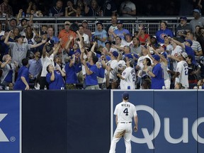 San Diego Padres left fielder Wil Myers watches as fans reach for a two-run home run by Chicago Cubs' Kyle Schwarber during the fourth inning of a baseball game in San Diego, Saturday, July 14, 2018.