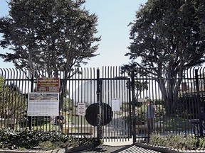 This Aug. 31, 2016, photo shows the gate to Opal Cliffs Park that leads to Opal Cliffs Neighborhood Beach, more commonly known as Privates surf break, in the Live Oak neighborhood of an unincorporated part of Santa Cruz County, Calif. The California Coastal Commission will decide whether access to a secluded beach can be restricted by a 9-foot iron fence, locking gate with a $100 annual key fee and a gate attendant. The commission on Thursday, July 12, 2018 will vote on whether the resident-run program that has regulated access to Santa Cruz County's Privates Beach for more than 50 years is allowed to continue.